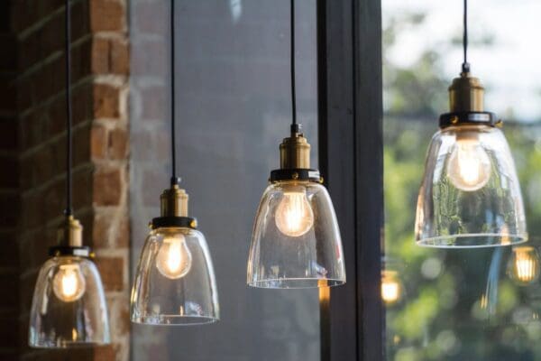 A group f bulbs hanging side by side in front of a window.