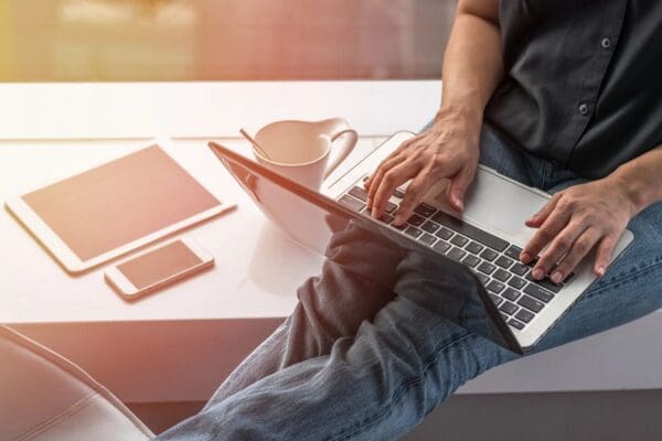 A person is using a laptop wearing a black shirt