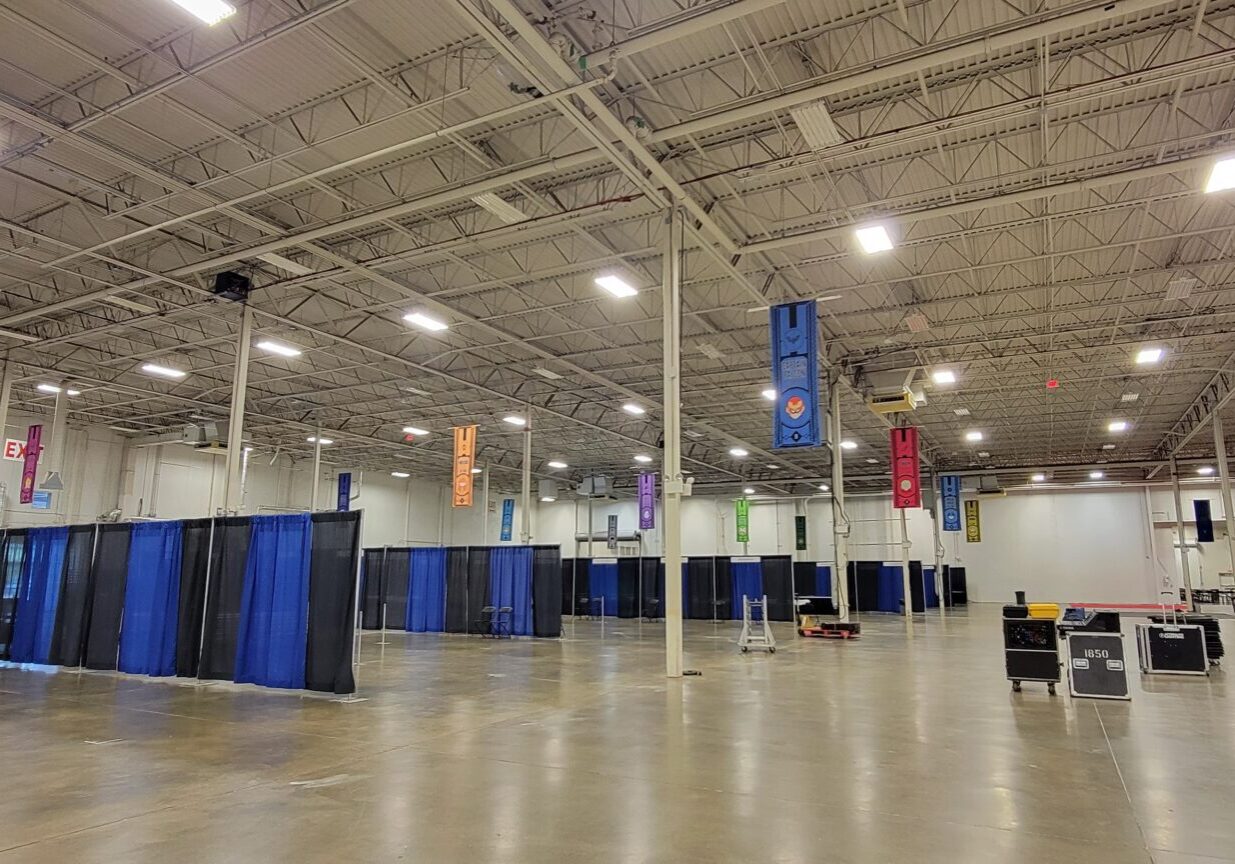 Large empty hall with blue curtains and banners.